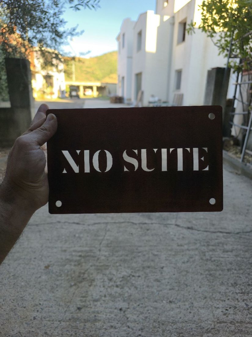 Piccola targa in CorTen con il nome della struttura traforato