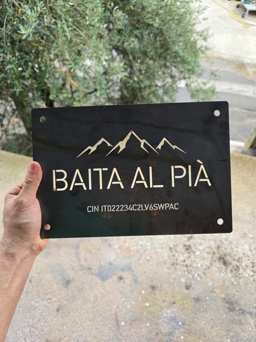 Targa in CorTen con profilo di montagne e nome traforati