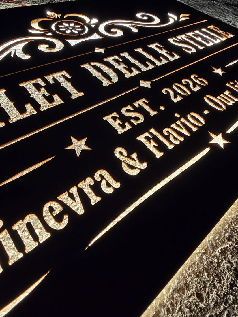 Insegna in CorTen retroilluminata di notte, con scritte e decori traforati