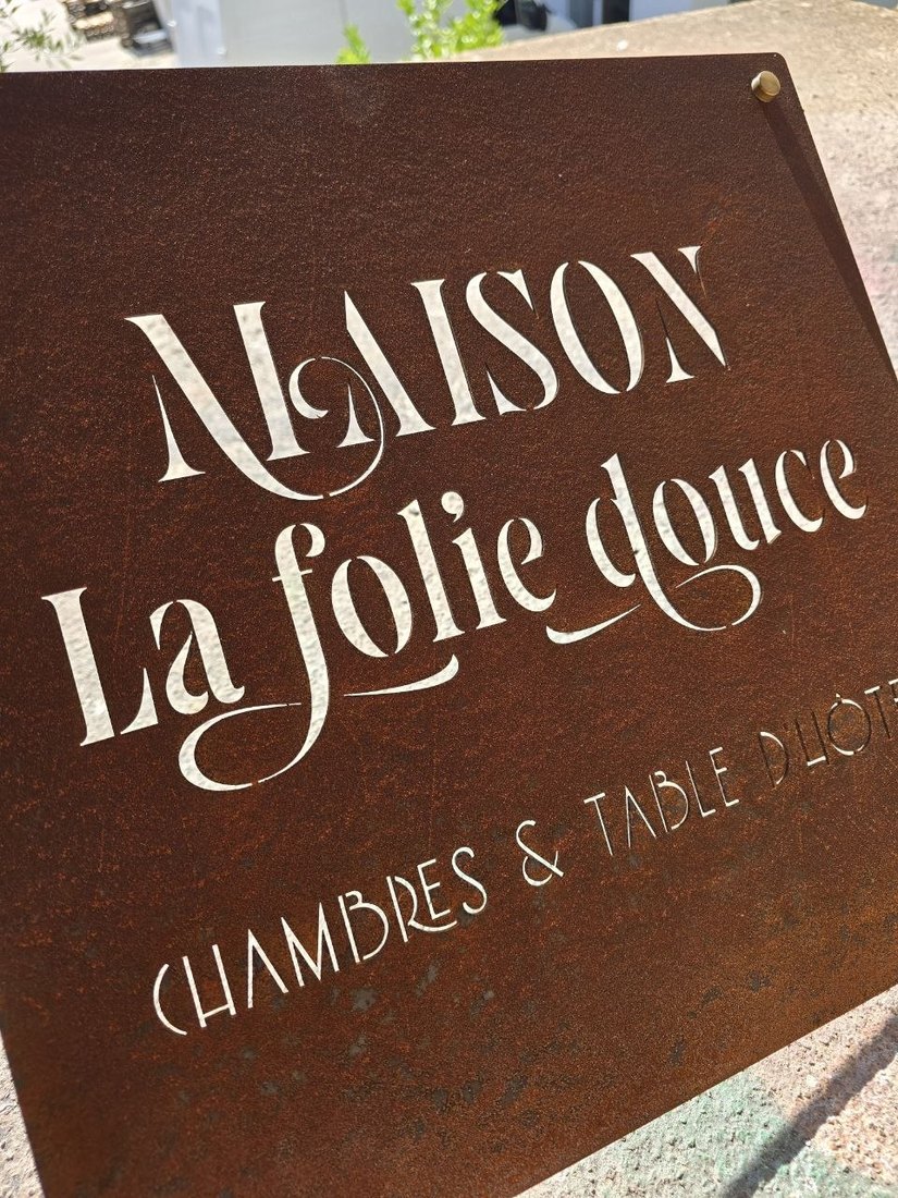 Targa in CorTen arrugginita con scritte calligrafiche traforate