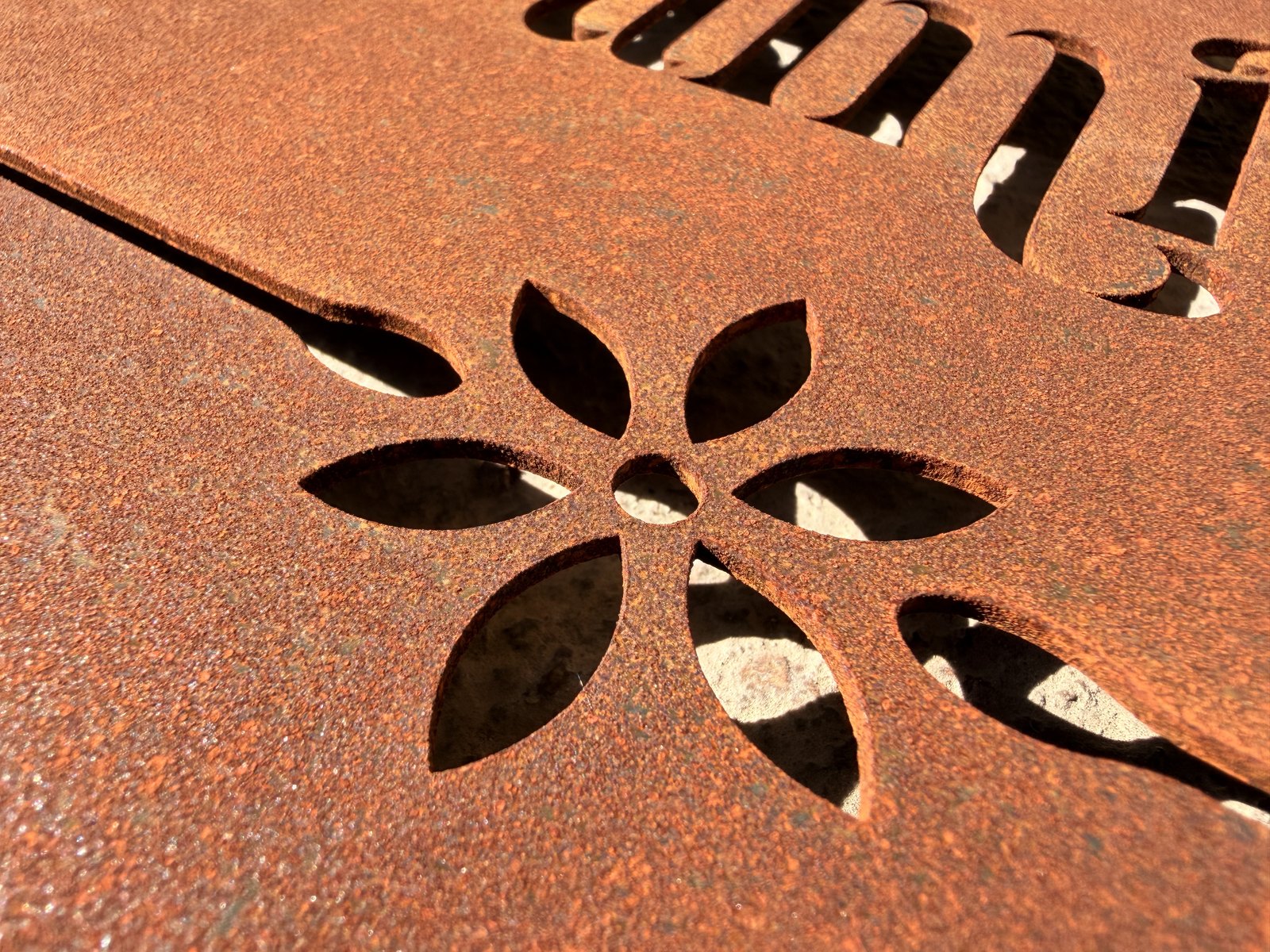 Fiore traforato in una lastra di CorTen arrugginito, da vicino